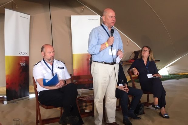 Jonathan Evans holding a microphone speaking at the Big Tent Festival 